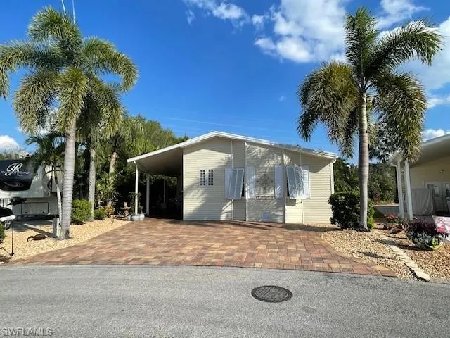 View of front of house with an attached carport and decorative driveway