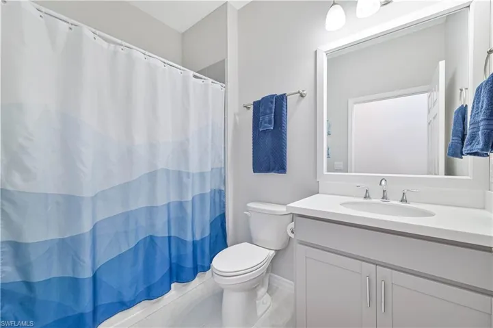 Full bathroom featuring curtained shower and vanity
