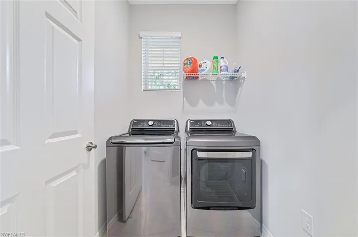 Laundry room with washing machine and clothes dryer and baseboards