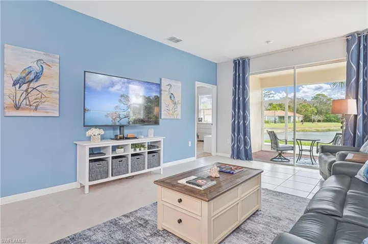 Living room featuring light tile patterned flooring and a water view