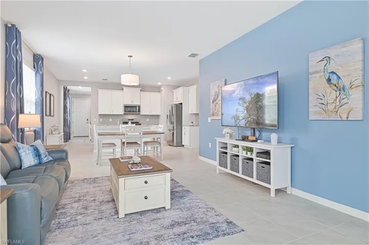 Living room with light tile patterned floors and recessed lighting