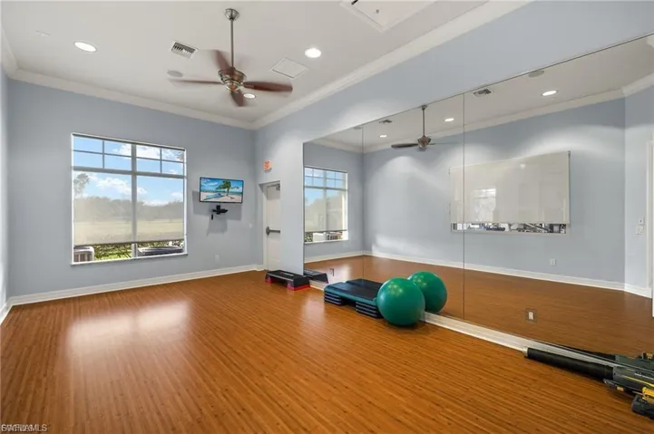 Exercise room with a ceiling fan, attic access, recessed lighting, and crown molding