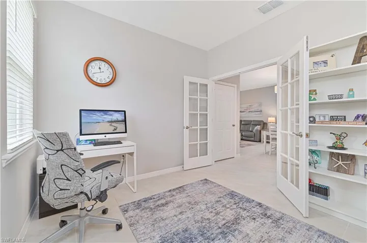 Office area featuring french doors and light tile patterned flooring