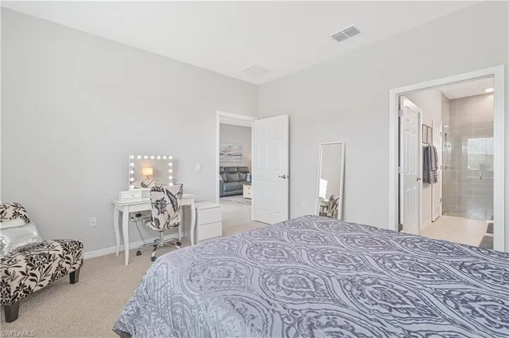 Bedroom with light colored carpet and ensuite bathroom