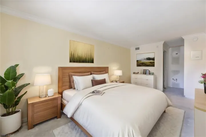 Carpeted bedroom with crown molding