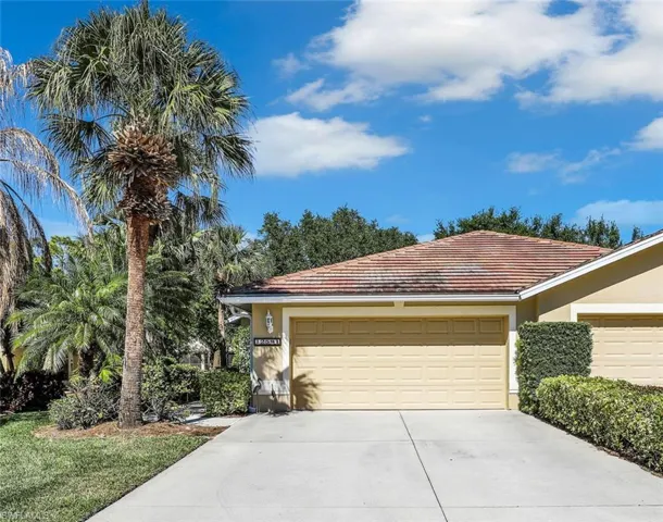 View of front of house featuring stucco siding, driveway, and a tiled roof