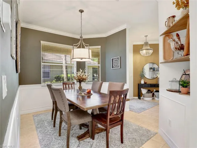 Dining room featuring light tile patterned floors and crown molding
