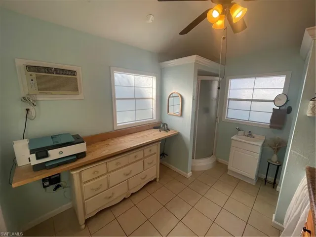 Bathroom with vanity, ceiling fan, a stall shower, and light tile patterned floors
