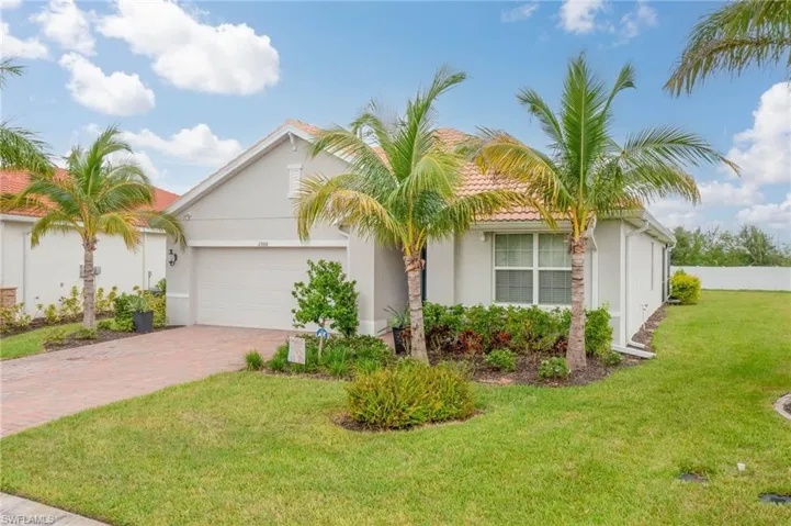 View of front of home with a front lawn and a garage