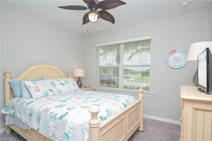 Carpeted bedroom featuring ceiling fan