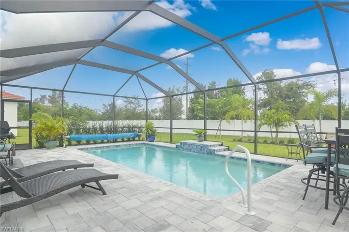 View of pool featuring a lanai, a patio, and a lawn