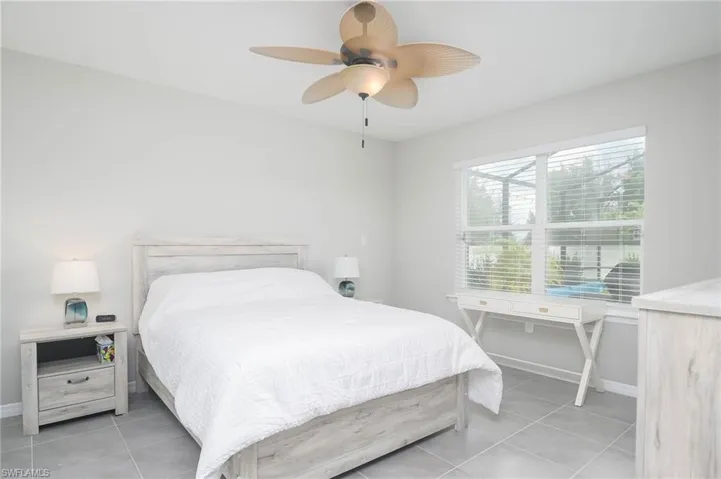Bedroom with ceiling fan and light tile patterned floors