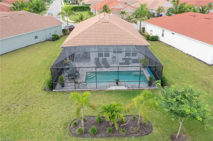 View of pool featuring glass enclosure and a yard