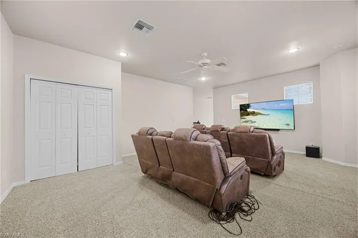 Cinema room featuring light colored carpet, recessed lighting, and a ceiling fan