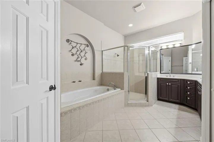 Bathroom with vanity, a stall shower, a garden tub, light tile patterned flooring, and recessed lighting