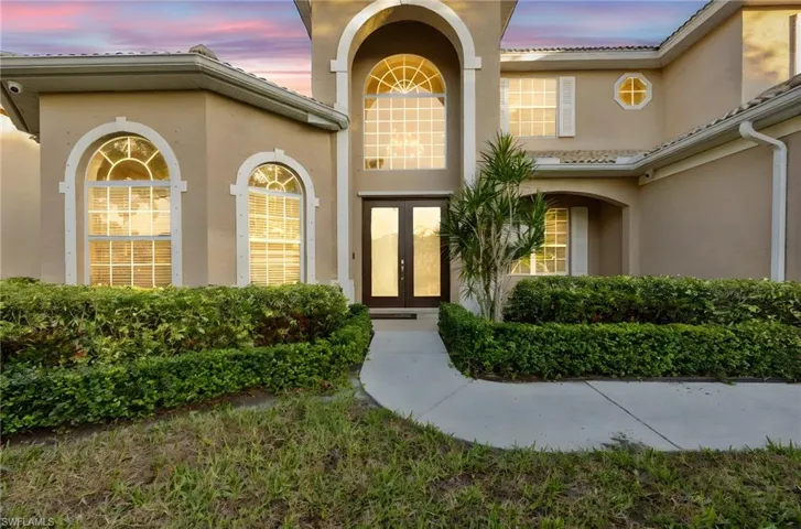 Exterior entry at dusk featuring french doors and stucco siding
