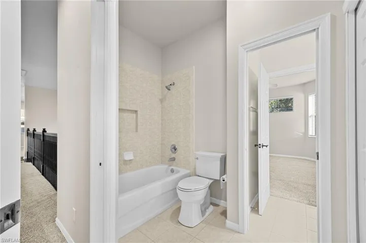 Full bath featuring shower / washtub combination, tile patterned flooring, and carpet