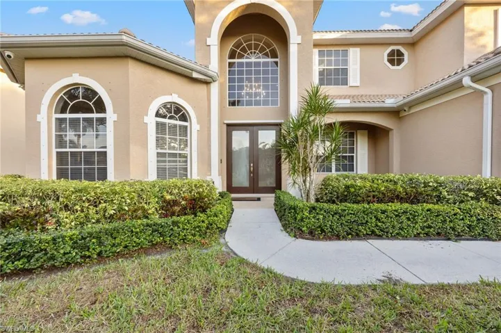View of exterior entry featuring french doors, stucco siding, and a tile roof