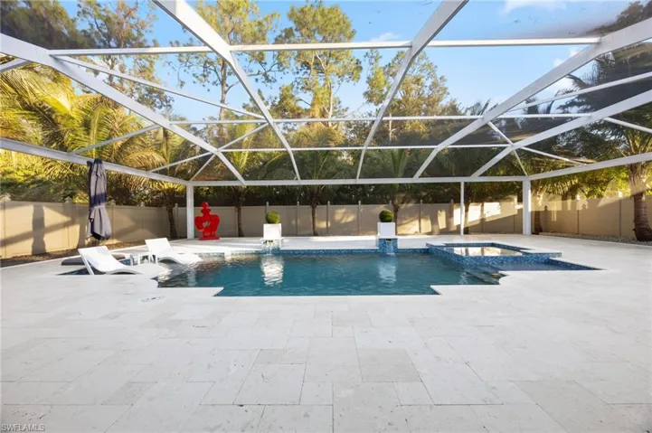 View of swimming pool featuring a fenced backyard, a lanai, a pool with connected hot tub, a patio, and a sunroom
