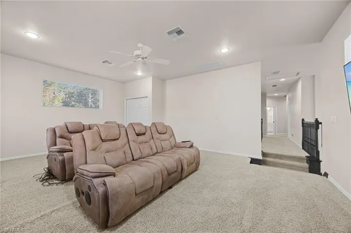 Carpeted home theater room featuring recessed lighting and ceiling fan