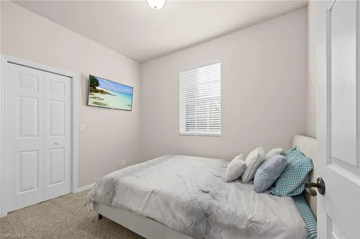 Carpeted bedroom with a closet and baseboards