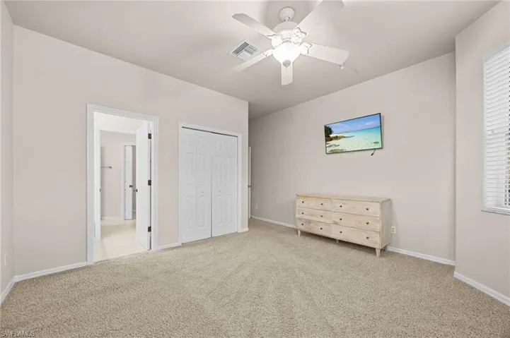 Bedroom featuring carpet, a ceiling fan, and a closet