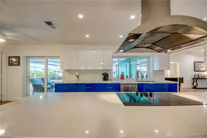 Kitchen with visible vents, stainless steel dishwasher, a sink, island range hood, and modern cabinets