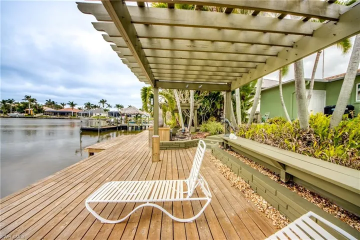 View of dock with a water view and a pergola