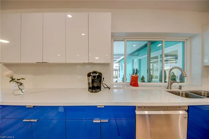Kitchen featuring light quartz counters, stainless steel dishwasher, two-tone European style cabinets