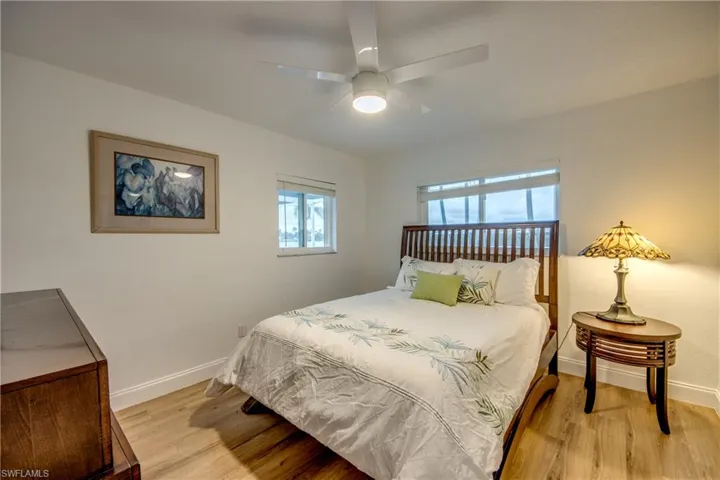 Bedroom with light wood finished floors, ceiling fan, and baseboards