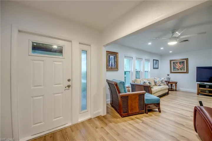 Foyer entrance featuring light wood-style floors, visible vents, baseboards, and a ceiling fan