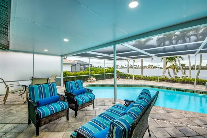 Outdoor pool with a lanai, a patio area, and an outdoor living space