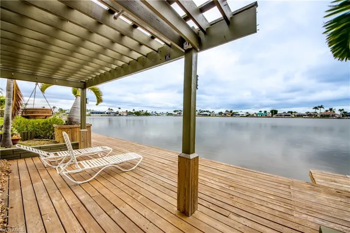View of dock featuring a water view and a pergola