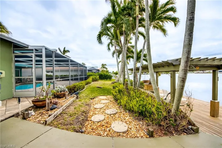 View of yard featuring glass enclosure and an outdoor pool