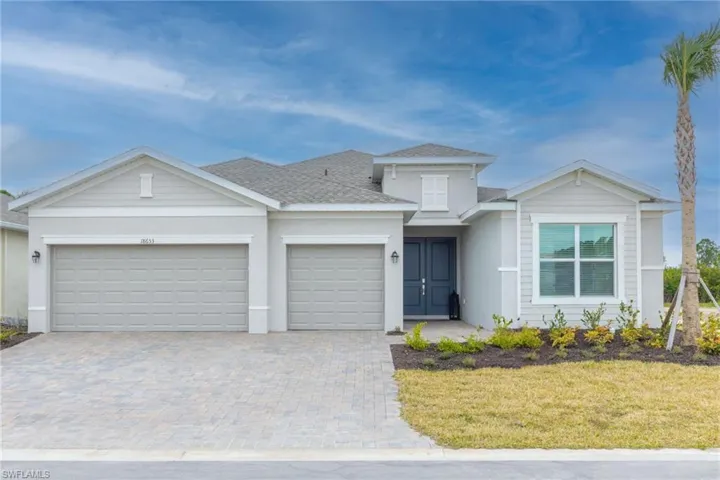 Contemporary gray exterior featuring two attached garages, a paved driveway, a double-door entry, a prominent front window with horizontal blinds, and a landscaped garden bed