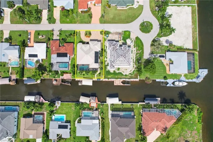 Direct access waterfront property featuring a private boat dock, in-ground swimming pool, and solar panel array with propane heat