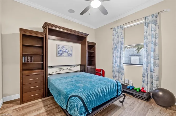 Guest bedroom 1 Integrated wood-finish wall unit featuring built-in shelving and drawers