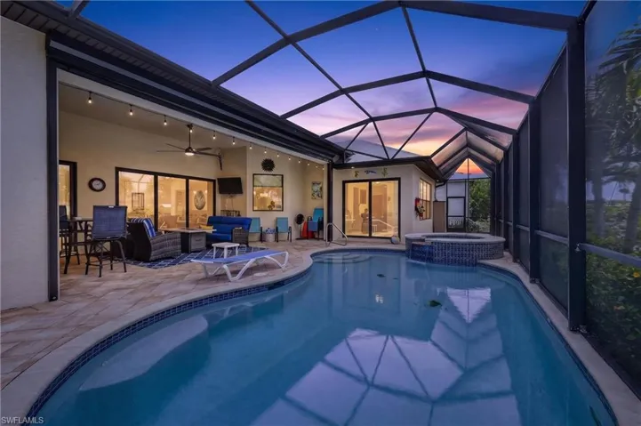 Screened lanai featuring a swimming pool with integrated spa