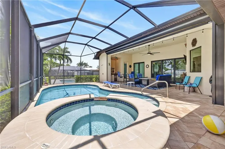Screened lanai featuring a swimming pool and built-in spa
