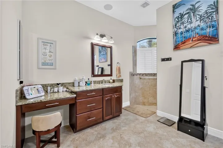 Spacious vanity area featuring wood cabinetry, a light-toned countertop, and an integrated dressing table