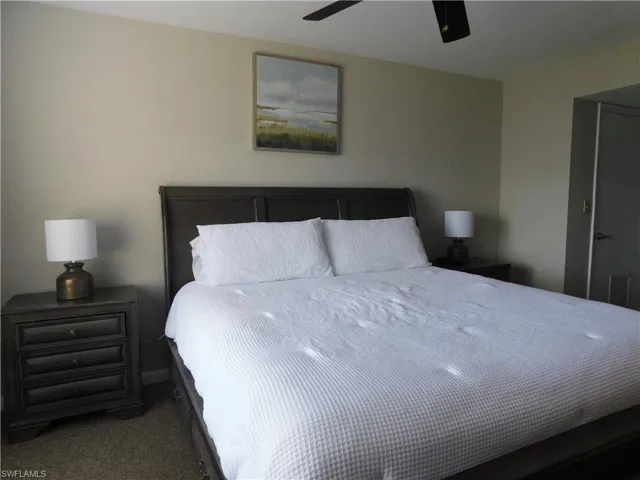 Bedroom with dark carpet and ceiling fan