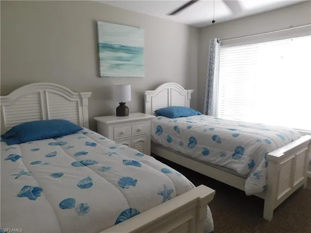 Bedroom featuring ceiling fan and dark carpet