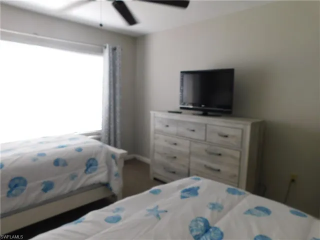 Bedroom featuring ceiling fan and multiple windows
