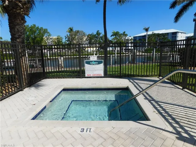 View of swimming pool featuring a community hot tub and a water view