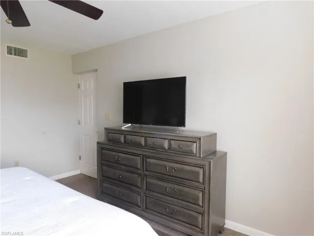 Bedroom featuring dark colored carpet and ceiling fan