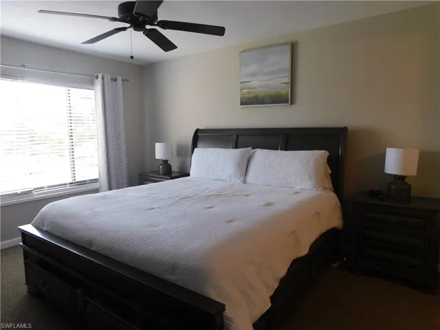 Carpeted bedroom featuring ceiling fan