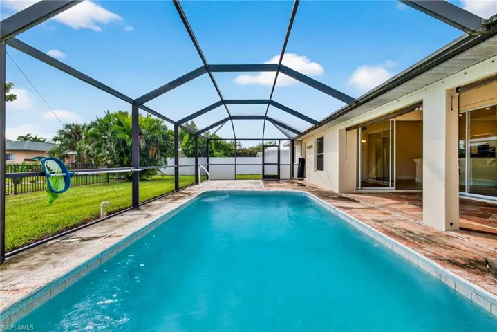 View of pool featuring a screened lanai, a patio