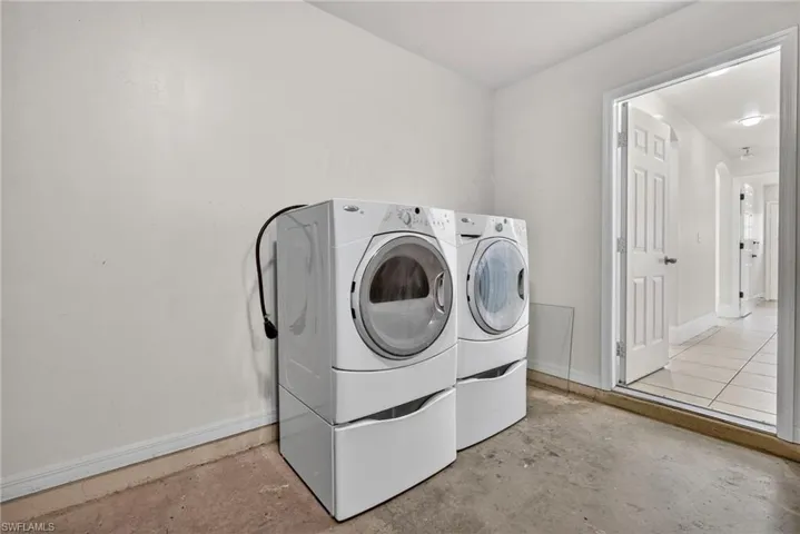 Laundry room featuring independent washer and dryer and unfinished concrete floors