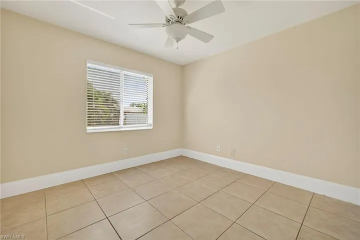 Unfurnished room featuring light tile patterned floors and ceiling fan