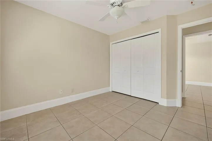Unfurnished bedroom featuring light tile patterned flooring, a closet, and ceiling fan